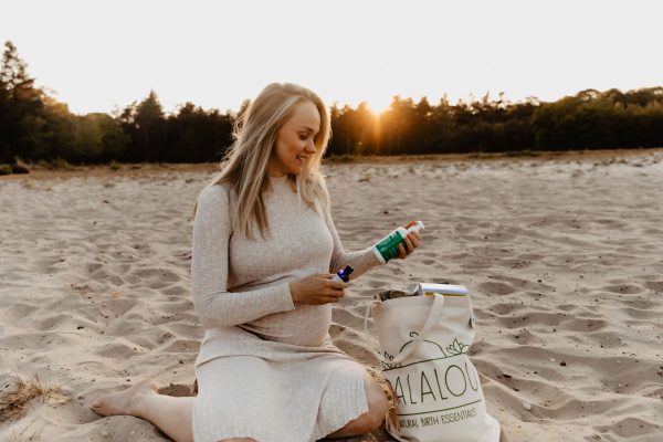 zwangere vrouw pakt producten uit bij ondergaande zon