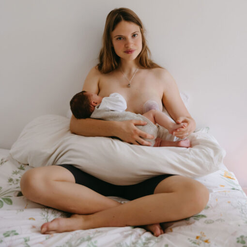 moeder kolft met baby aan borst