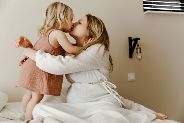 moeder geeft dochter kus