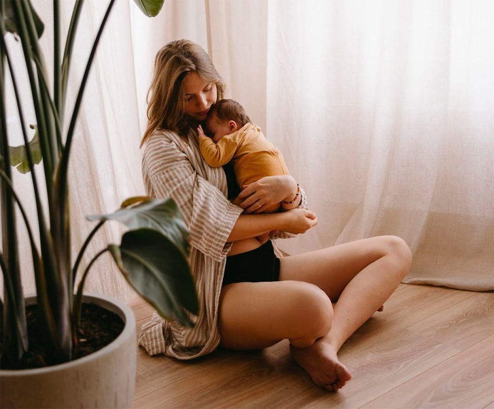 vrouw met baby in armen dicht bij elkaar in huiselijke setting