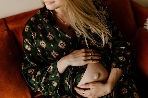 zwangere vrouw met handen op de buik