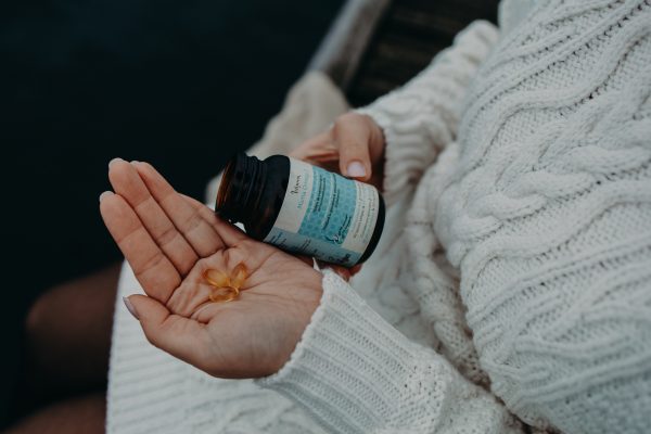 zwangere vrouw met omega capsules in haar hand