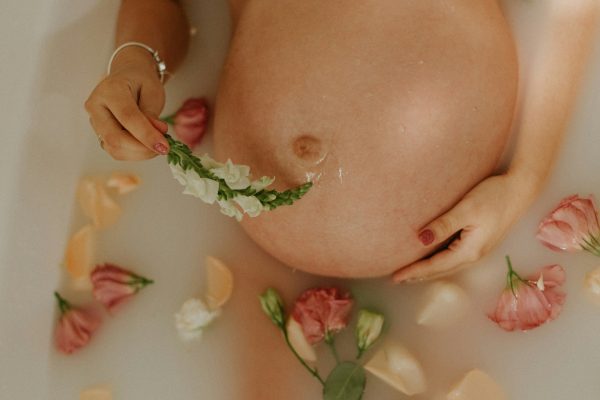 zwangere buik in bad met bloemen
