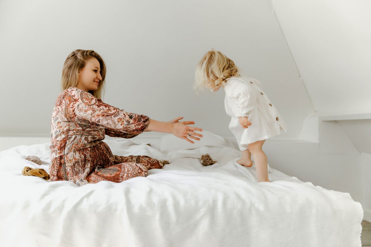 zwangere vrouw op bed met jong kindje