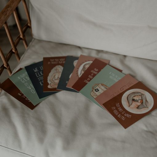 10 affirmatiekaarten postpartum op een rij op stoel