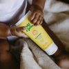 baby houdt tube minerale zonnebrandcreme in handjes