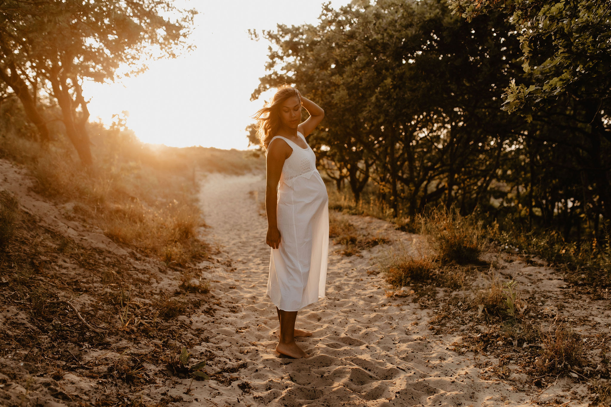 zwangere vrouw bij zonsondergang in de natuur
