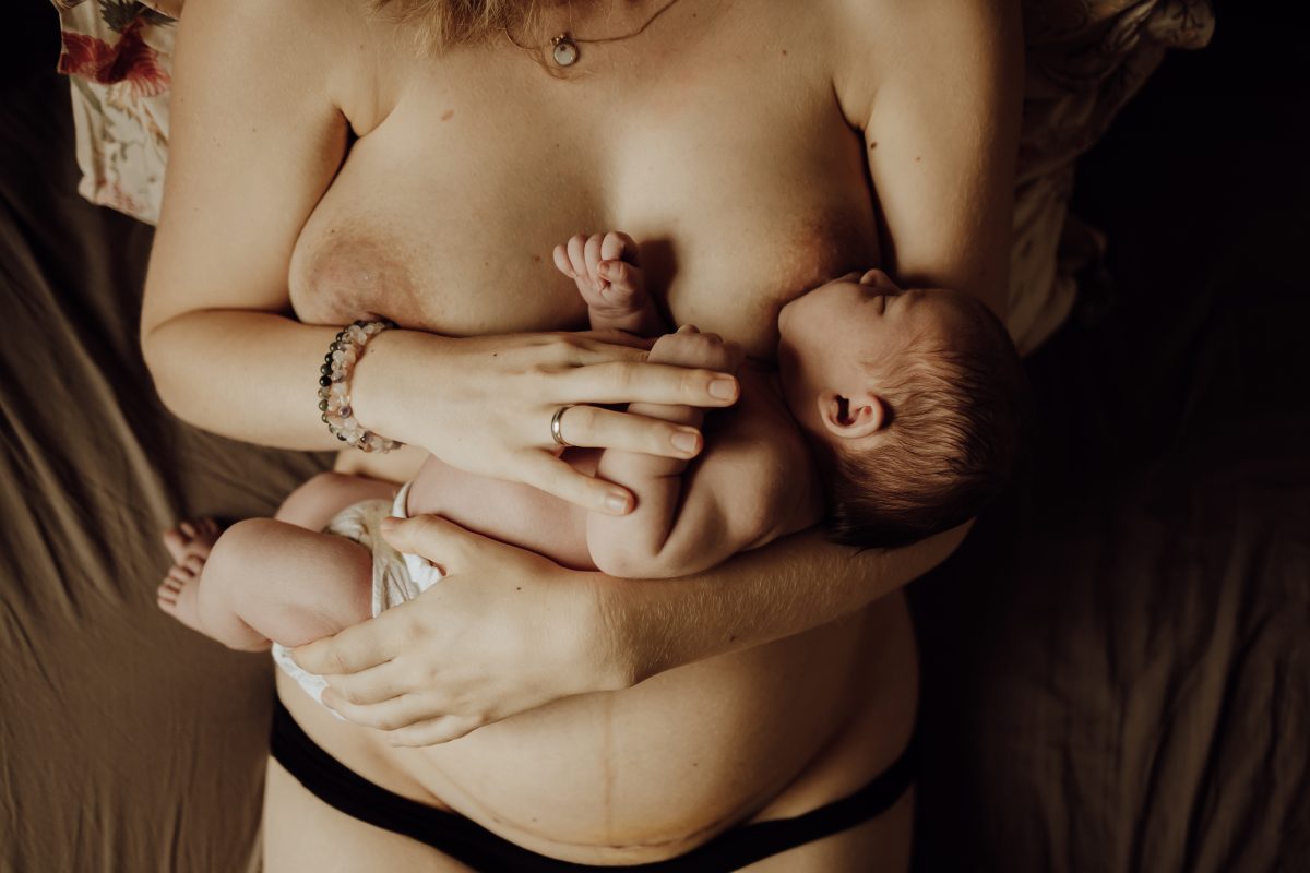 moeder met baby aan borst half liggend natuurlijke houding